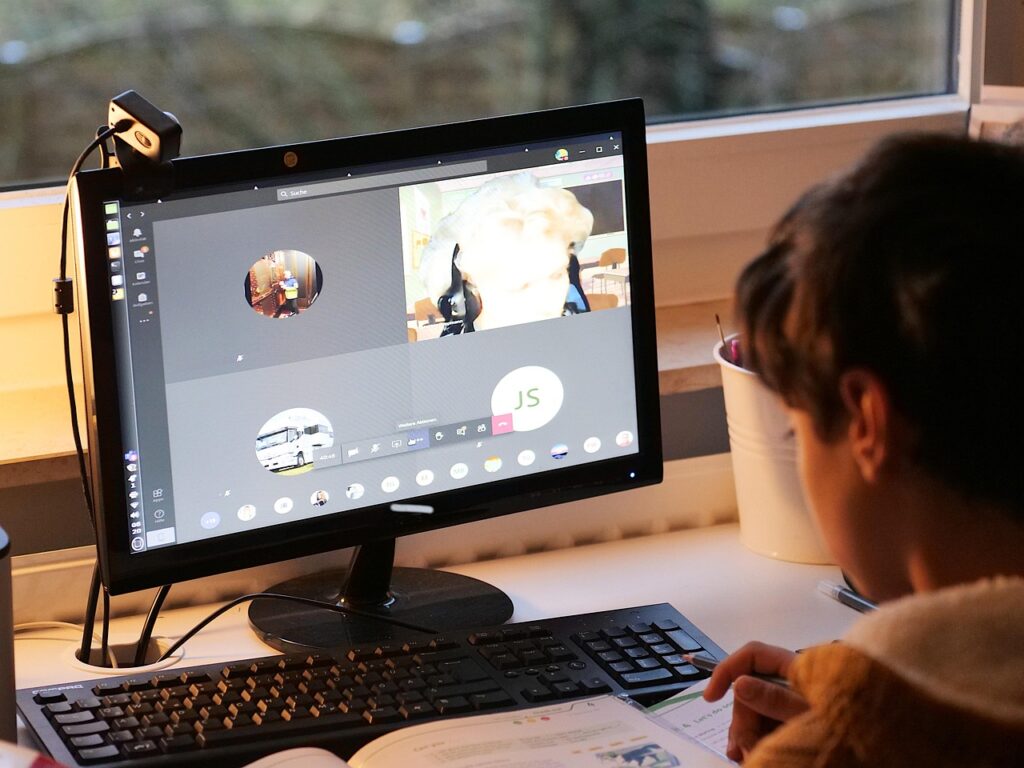 Un enfant apprend à la maison grâce à une tablette, utilisant des ressources numériques pédagogiques.